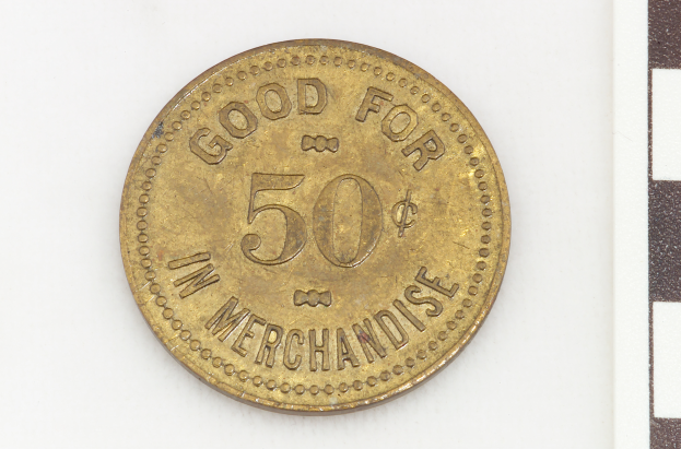 Eine Goldmünze mit der Aufschrift "Gut für 50 in Ware" auf einem weißen Hintergrund.