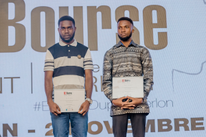 Zwei Männer stehen nebeneinander auf einer Bühne, jeder hält eine Urkunde in der Hand, im Hintergrund ein 'Bounce Awards 2019'-Plakat.