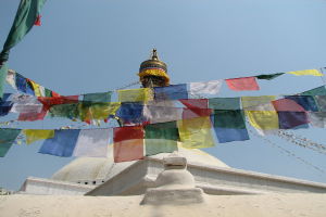 Ein weißer Grabstein, der mit zahlreichen bunten Fahnen geschmückt ist.