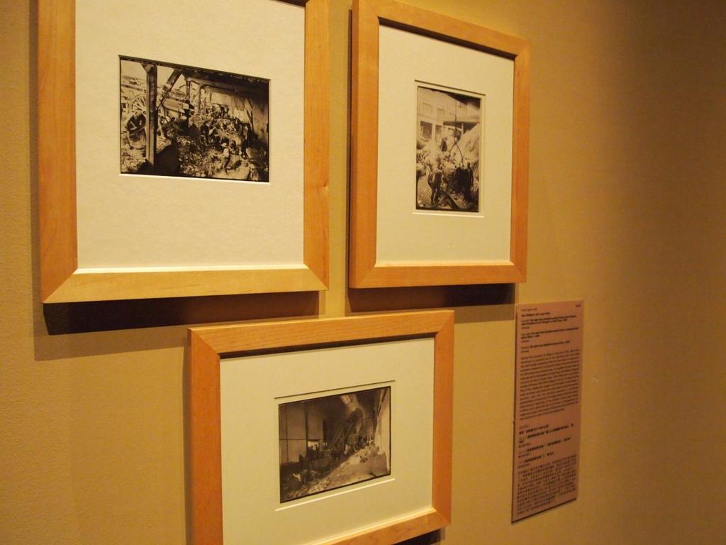 Eine Wand mit mehreren gerahmten Bildern und einem Plakat mit Text, möglicherweise zeigt es eine Scheune und Gebäude.