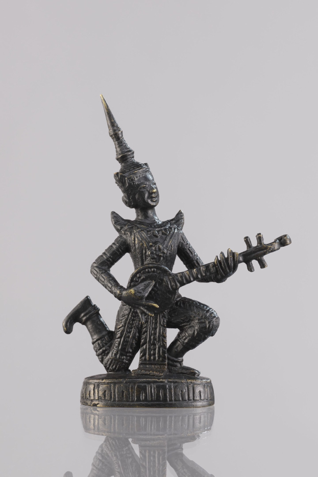 Bronzestatue eines Mannes mit einer Gitarre vor einem weißen Hintergrund.