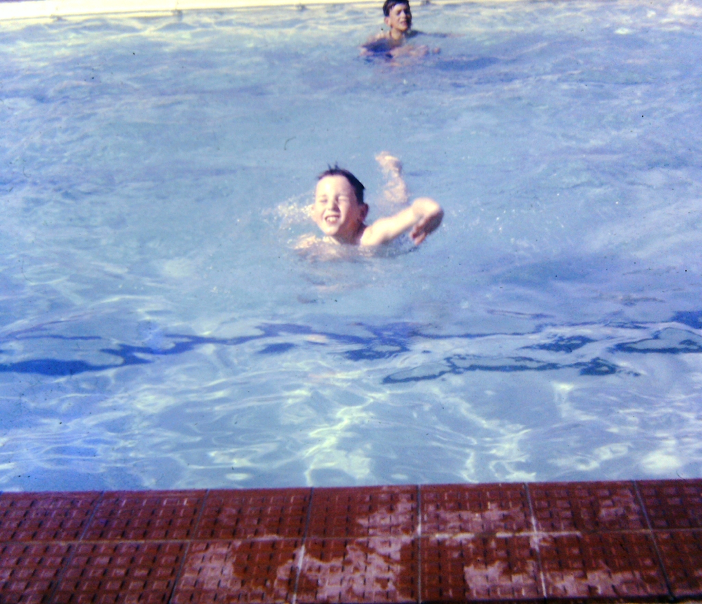 Zwei Kinder schwimmen in einem mit Wasser gefüllten Pool.