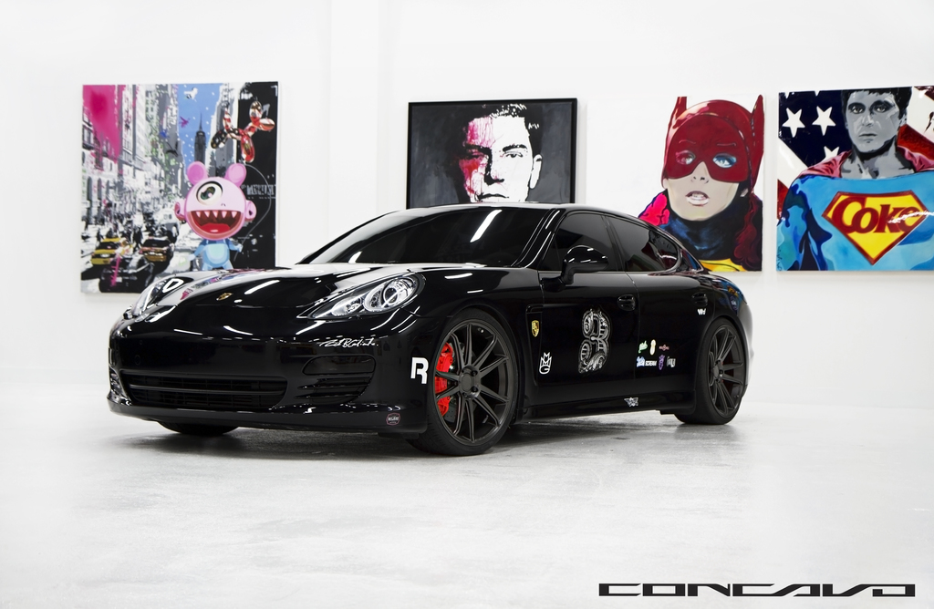 Ein schwarzer Nissan-Sportwagen mit Cartoon-Postern im Hintergrund und einer kleinen Inschrift unten.