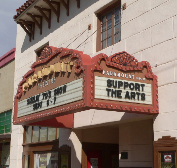 Außenansicht des Paramount Theatre in Sacramento, Kalifornien, mit Glasfenstern und -türen und einer 'Support the Arts'-Schrifttafel über dem Eingang, vor einem Himmel-Hintergrund.