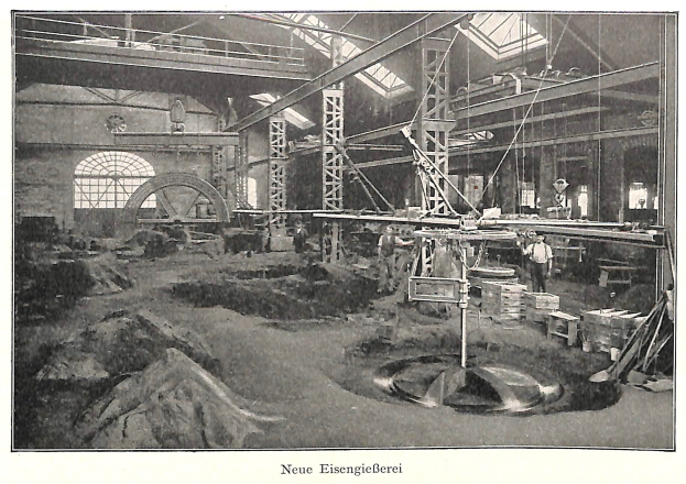 Schwarzes und weißes Foto einer Fabrik mit Arbeitern, die Maschinen bedienen, umgeben von Metallstangen und -pfählen, beschriftet mit "Neue Eisengießerei, die erste Fabrik in Deutschland" unten.