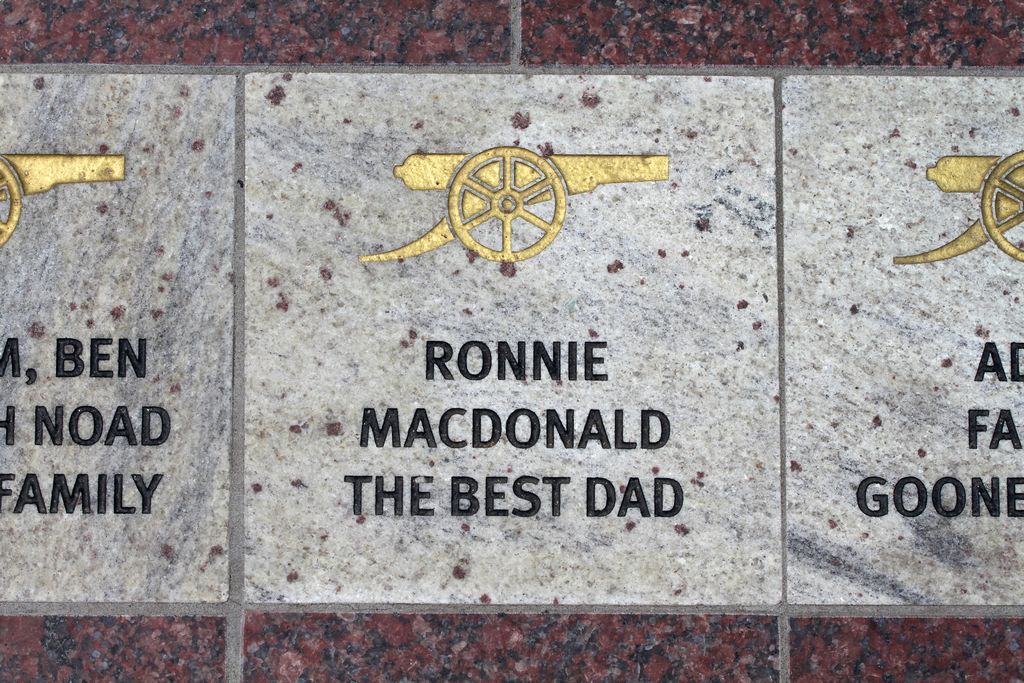 Ein historisches Schild mit Symbolen und Text in der Mitte des Bildes.