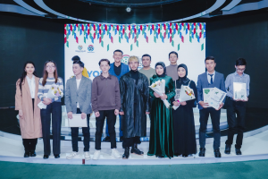 Gruppe von Menschen auf einer Bühne mit Blumensträußen und Urkunden, vor dem Hintergrund "Youth Solar Awards 2019"