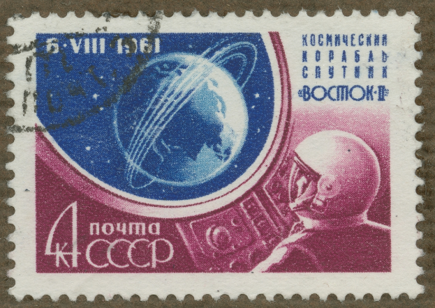 Eine Briefmarke mit einem Mann im Weltraumanzug mit entschlossener Miene, umgeben von der fett gedruckten Textzeile "Stamp" in weißer Schrift.