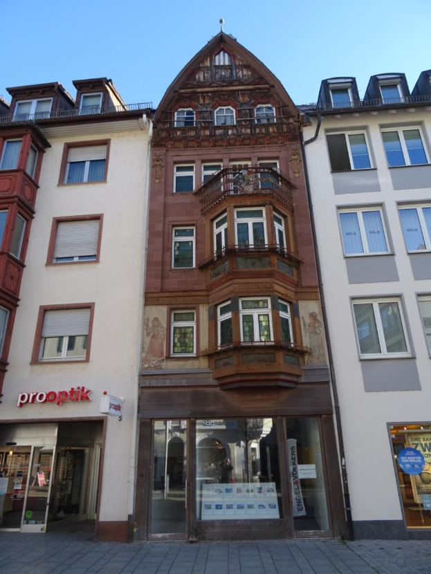 Gewerbeimmobilie zum Verkauf in Heidelberg, Deutschland, mit einem mehrfenstrigen Gebäude neben einer Straße unter einem klaren blauen Himmel.