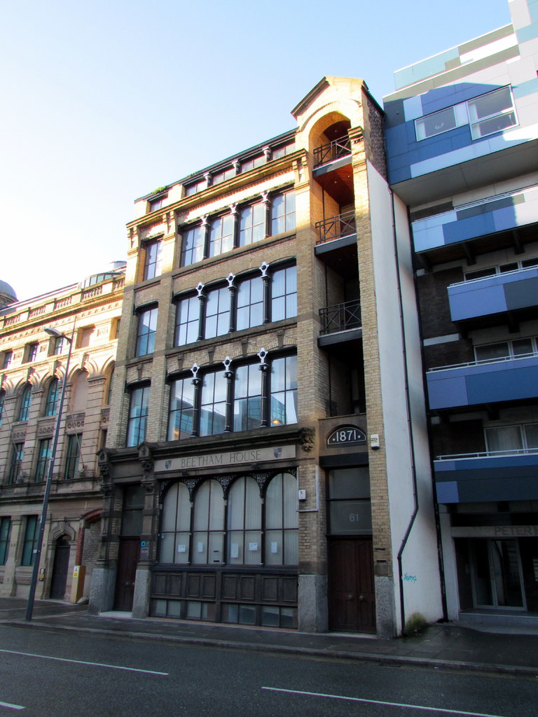 Mehrere Geb├Ąude mit einem Pfahl in der linken Ecke und einer Stra├če davor.