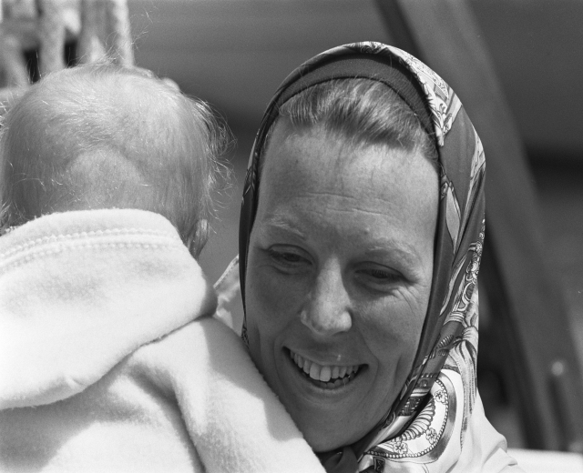 Eine Frau, die glücklich ist und ein Baby hält, mit einem sanft unscharfen Hintergrund.