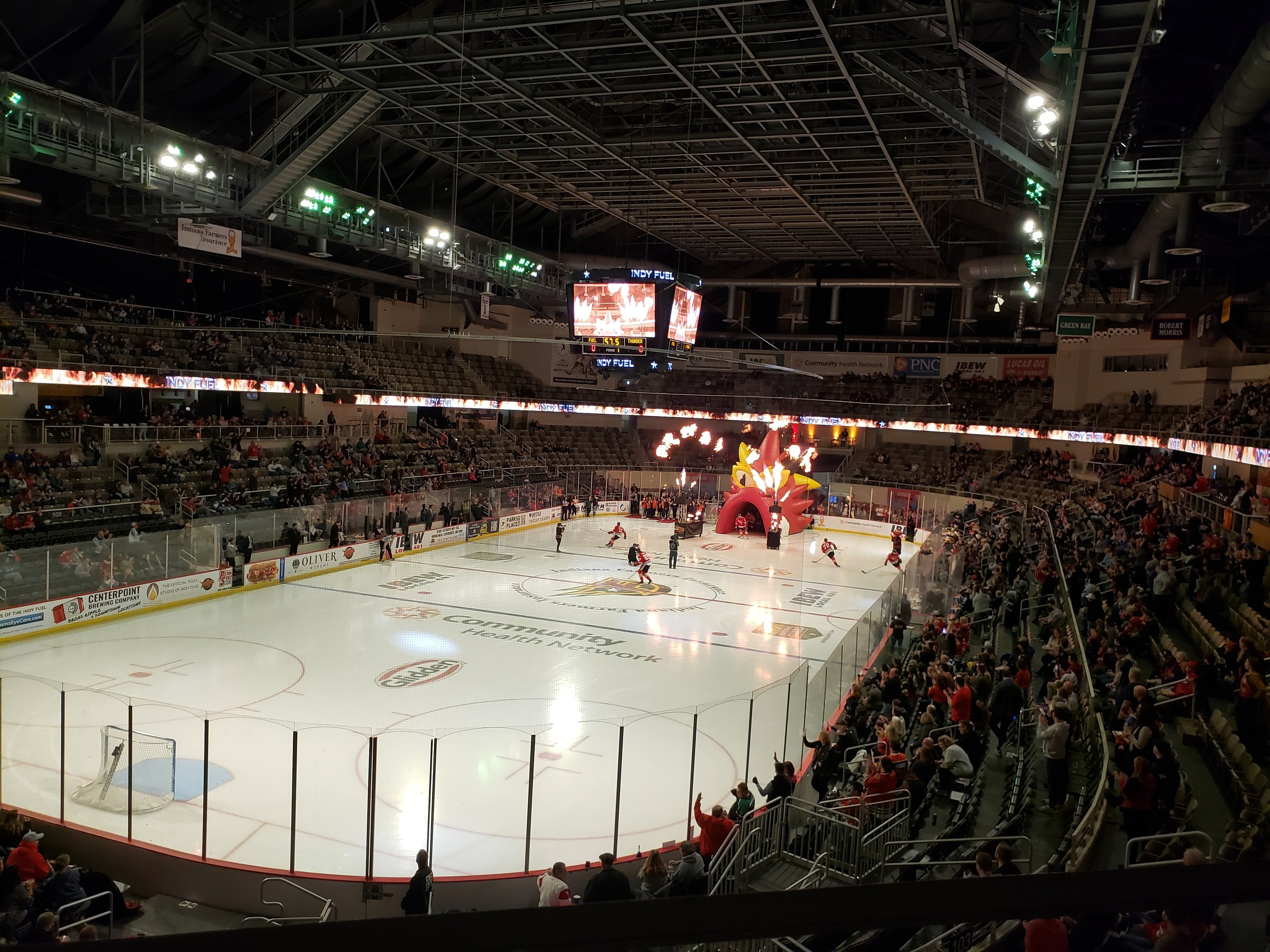 Ein Eishockeyspiel im Columbus Blue Jackets Stadion, mit Spielern auf dem Eis umgeben von einem Zaun, Zuschauern auf Sitzen und Stehplätzen und Bannern über den Boards.