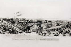 Ein altes Schwarz-Weiß-Gebäude mit zahlreichen Gebäuden, Bäumen, Fahrzeugen auf der Straße und Rauch aus Schornsteinen, mit der Beschriftung "Noblefabrik Gebreuder Thonet in Bystritz, Deutschland" unten.