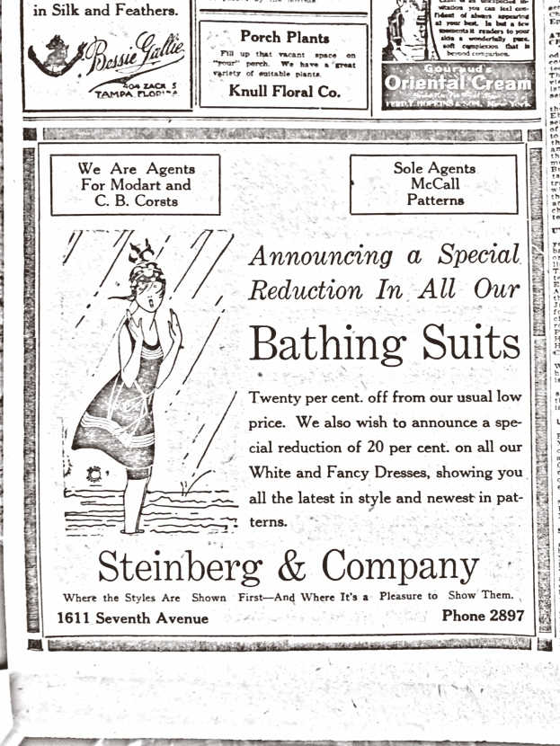 Eine Frau in einem weißen hochgeschlossenen, langärmeligen Kleid mit einem Dutt, die in der Mitte einer Steinberg & Company-Badeanzugwerbung steht, mit geschlossenen Augen und friedlichem Gesichtsausdruck.