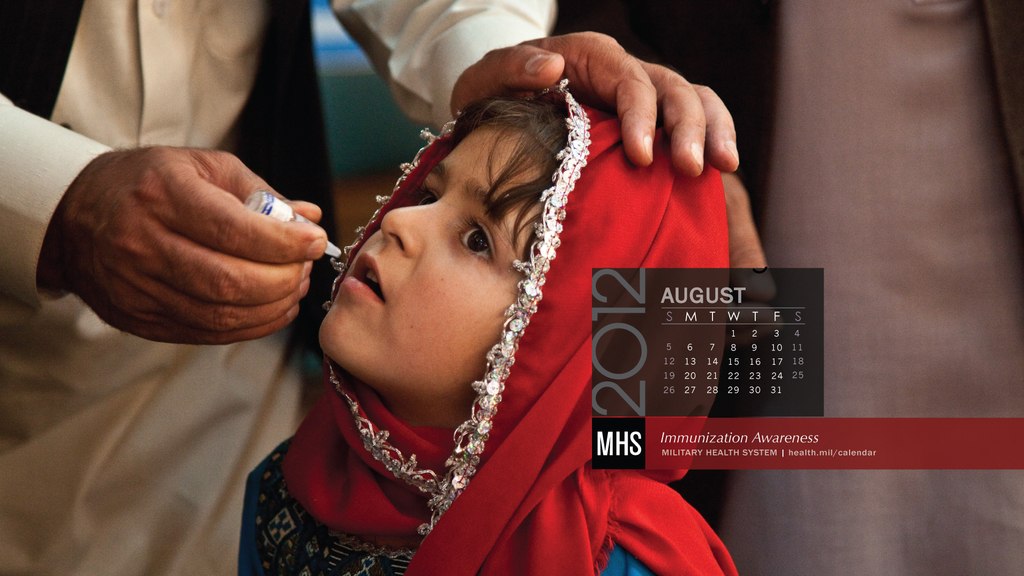 Eine Gruppe von Menschen, die mit einer Person stehen, die eine Impfstoffflasche, einen Kalender und sichtbaren Text hält.