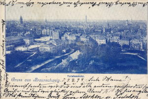 Alte Postkarte zeigt eine Stadtansicht von einem Hügel mit Gebäuden, Bäumen und handgeschriebenem Text.